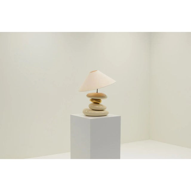Large Pebble table lamp by François Chatain, 1980s France. Four ceramic pebbles, one gold and 3 off white. The angle of...