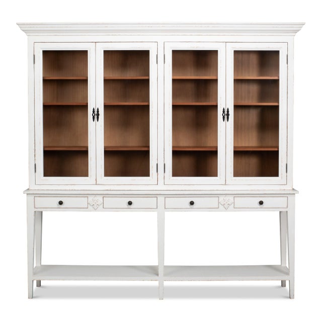 Four divided-pane glass doors rise above an open stand with drawers, pairing a white exterior with warm natural wood...