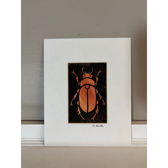 A complementary pair of original hand-carved beetle prints, presented as a cohesive set. Each piece features a bold black...