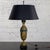 Marvelous vintage Neoclassical table lamp composed of an antiqued brass finish body with ornate embossed details, black...