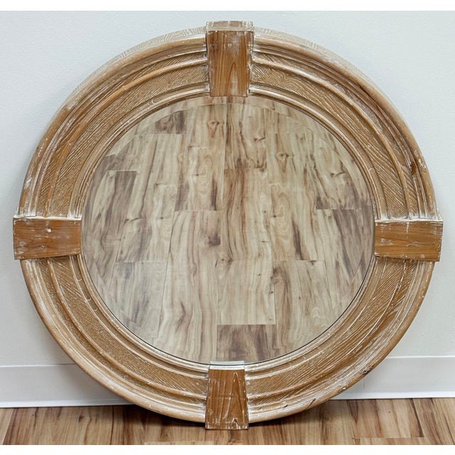 Large round wall mirror features a distinctive circular frame composed of individual carved weathered wood panels joined...