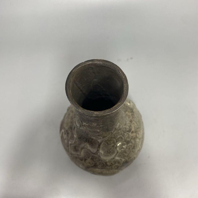 This exquisite vintage metal vase features a classic pear shape and is heavily decorated with intricate bas-relief motifs....