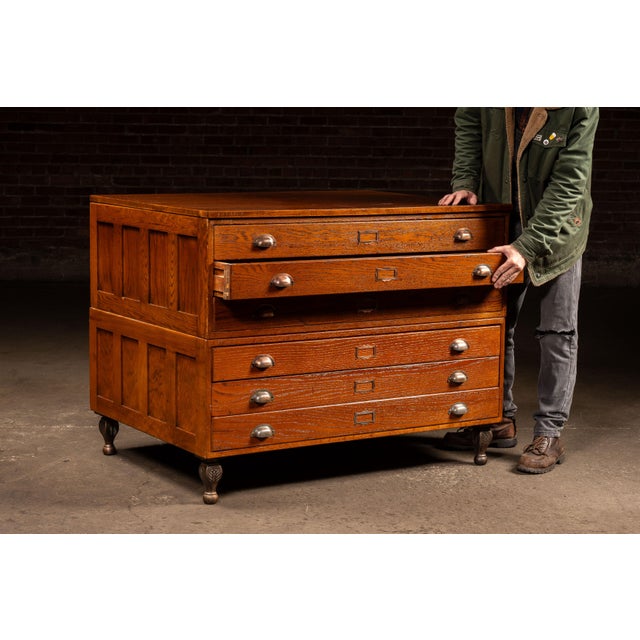 Substantial oak flat file cabinet with six uniform shallow drawers, designed for storing large-format documents,...