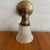 Dating from the early 20th century, this early industrial wall sconce features a solid brass pipe arm with mottled, time-...