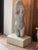 Modernist carved stone female torso with smooth, rounded forms and natural mineral markings, mounted on a painted wood base.
