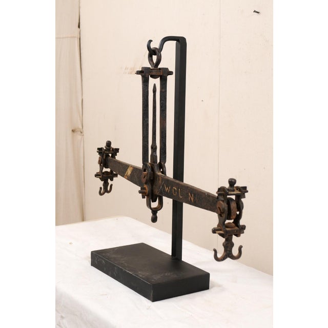 A French iron scale from the mid 20th century presented on custom iron stand. This vintage scale from France is a sizable...