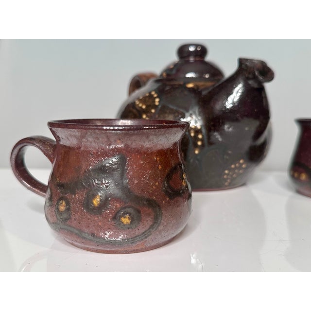 This handcrafted set from the workshop of Helma Klett (1908-1996) consists of a bulbous teapot and two matching cups, each...