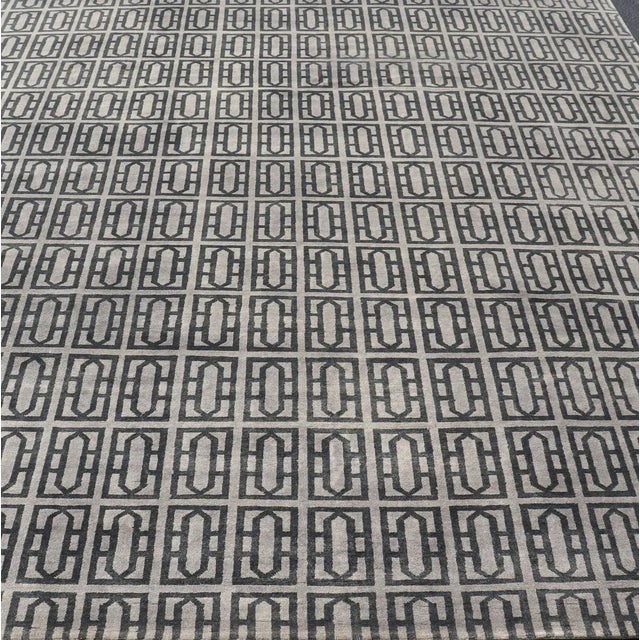 This modern Indian rug has been hand-knotted in wool and features an all-over geometric design rendered in gray and black...