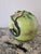 A generously sized Chinese altar fruit modeled as a ripening peach, blushing from soft green to deep raspberry pink at the...