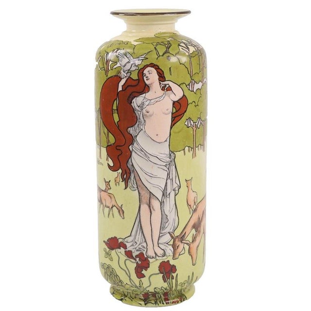 A draped maiden depicting Psyche forms the central pictorial focus, her long auburn hair trailing as she holds a white...