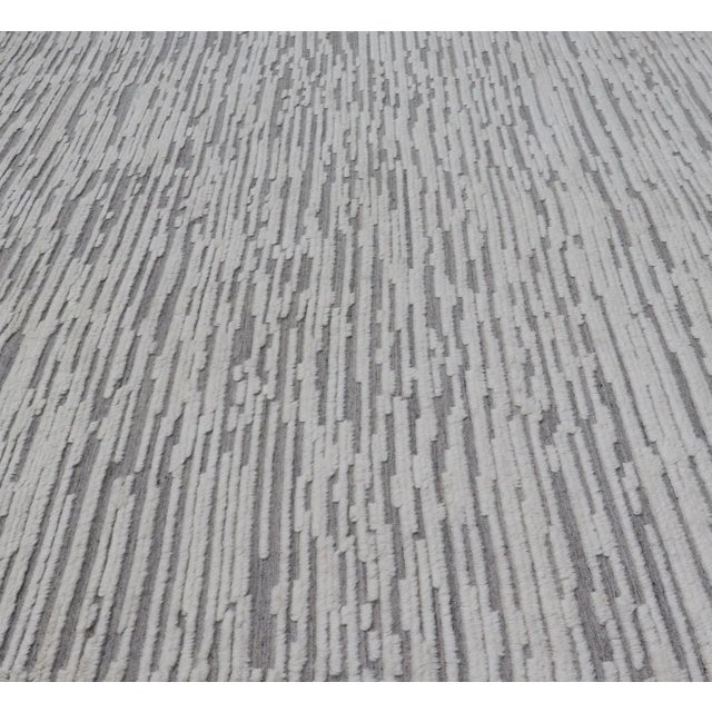 Measures 11'8 x 14'0 This modern area rug was hand-knotted in the 2020's. The field is a wood grain-like pattern,...