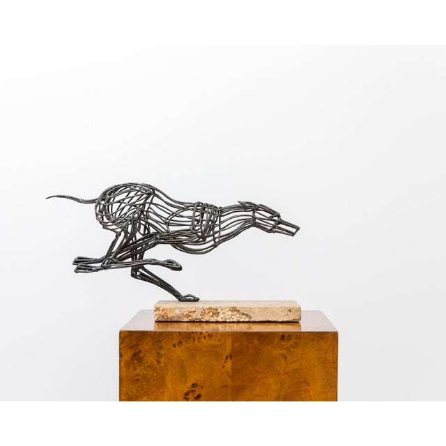 A finely executed welded steel sculpture depicting a running greyhound, signed "Gabris" and mounted on its original solid...