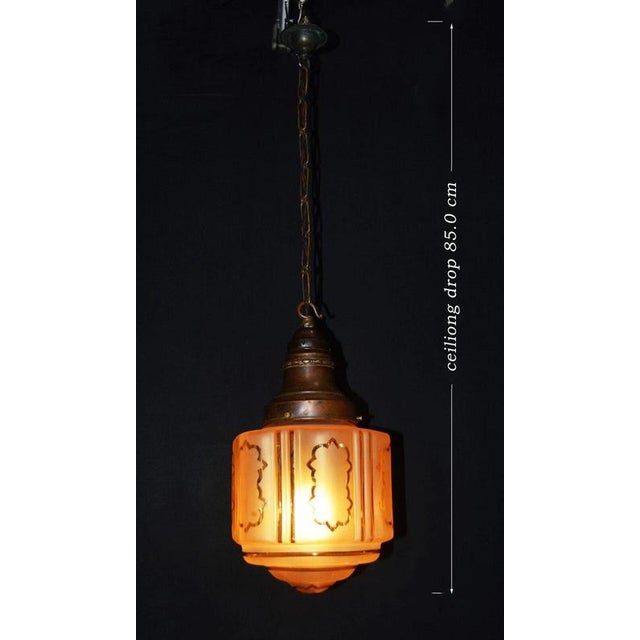 An evocative early 20th-century Art Nouveau pendant light, circa 1910, combining a dramatic hand-moulded, hand-blown glass...