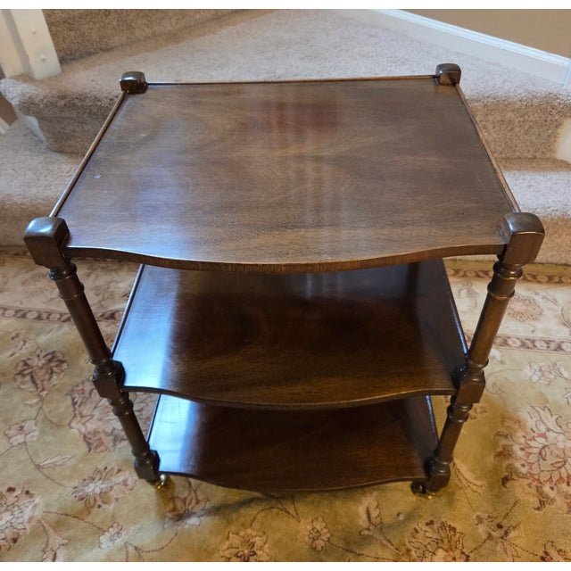 Beautiful mid-century three-tier table with slight bow on the front and solid brass casters. This is high-quality...