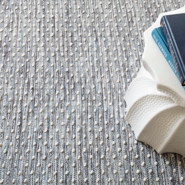 Multi marled ground of indigo, blue, ivory, and black resembles acid washed denim with raised hobnail neps for a pleasing...