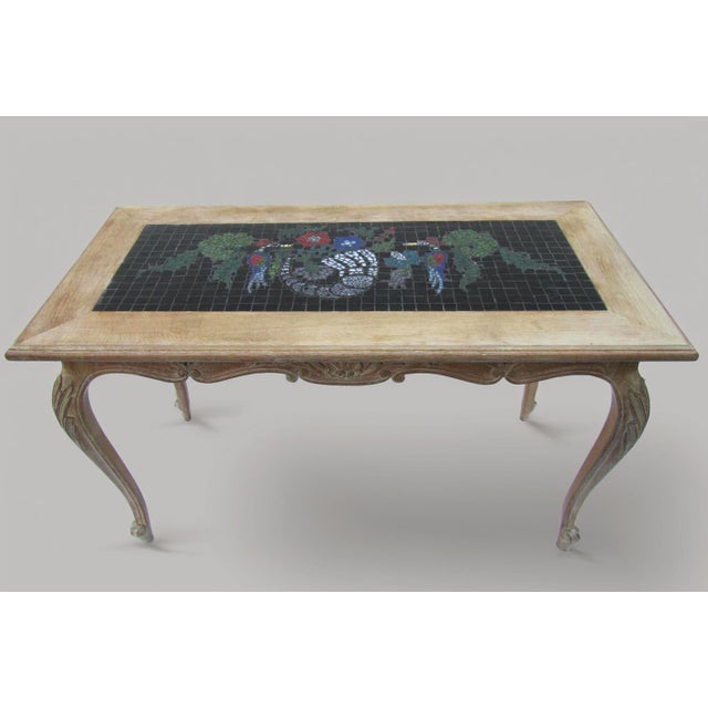 This is a vintage French Louis XV-style solid oak coffee table from the 1970s with an inlay ceramic mosaic top. Handmade...
