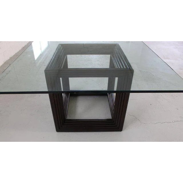 Very sharp looking rattan cube shape base thick glass top square dining or conference table. Made in the 1970s.