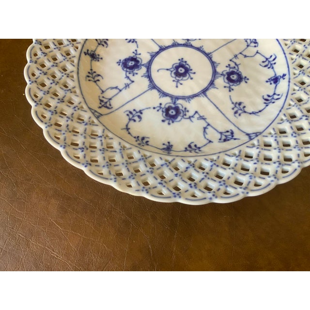Recognized for its hand pierced reticulated (open work lattice) border.