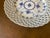 Recognized for its hand pierced reticulated (open work lattice) border.