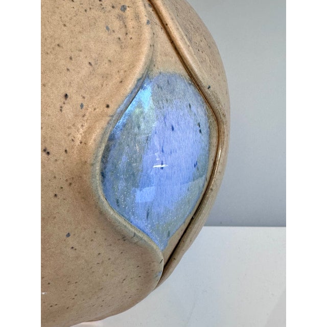 This hand-sized ceramic vase impresses with its sculptural presence and a substantial diameter of approximately 23 cm. The...