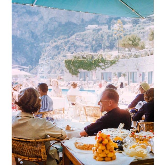 Lunch In Capri by Toni Frissell Holidaymakers enjoy a meal at a beachside restaurant in Capri, Italy, 1959. (Photo by Toni...