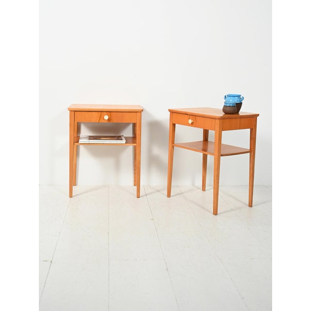 Pair of Scandinavian beech bedside tables from the 1950s and 1960s, with a drawer, magazine rack, and Bakelite handle:...
