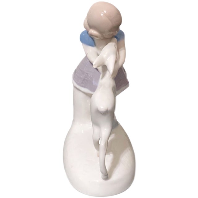 A delicate and heart warming vintage porcelain figurine capturing a tender moment between a young girl and a fawn. This...