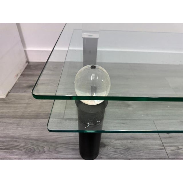 An architectural two tiered coffee table with geometric design elements featuring four alternate shapes on the lower tier...