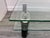 An architectural two tiered coffee table with geometric design elements featuring four alternate shapes on the lower tier...