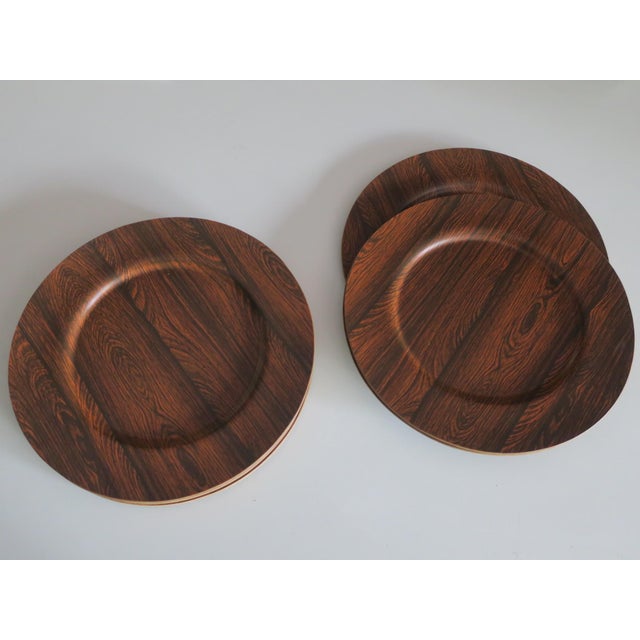 12 plates from Morsbak, Denmark 1960s, made of plywood with the top plywood layers in teak and rosewood. This piece has an...