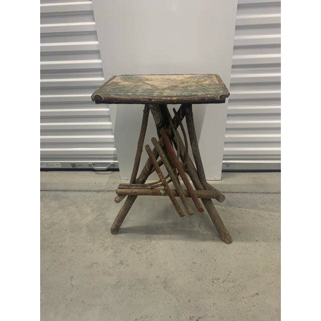 Early 20th century American Adirondack table constructed from twigs, with a bentwood half-horseshoe decorating the front...