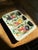 This Italian mid-century piece is a white ceramic serving platter with three compartments, featuring a hand-painted fruit...