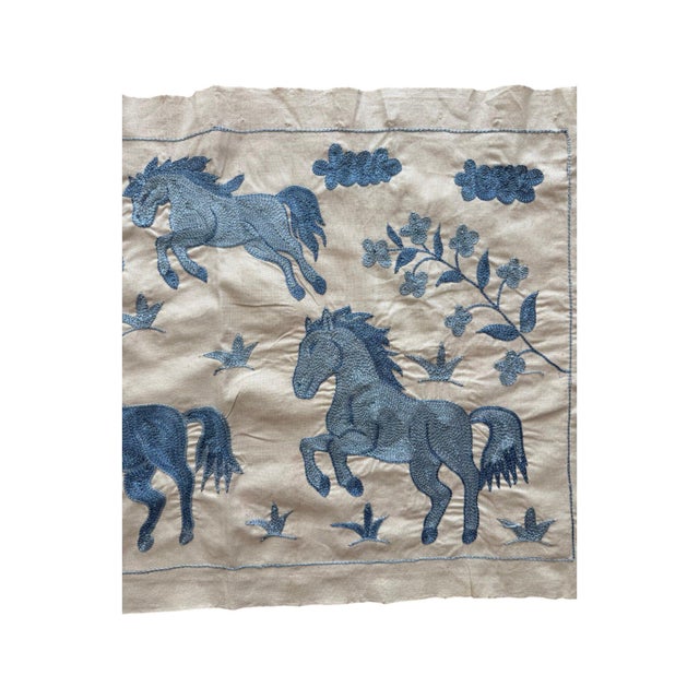 Hand-embroidered Suzani panel from Uzbekistan, worked in fine floss on a cream cotton ground. Six blue horses move across...