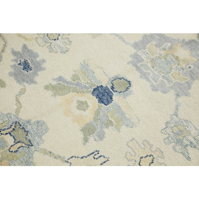 This modern Turkish Oushak rug is a stunning piece of art that has been handwoven using traditional techniques by skilled...