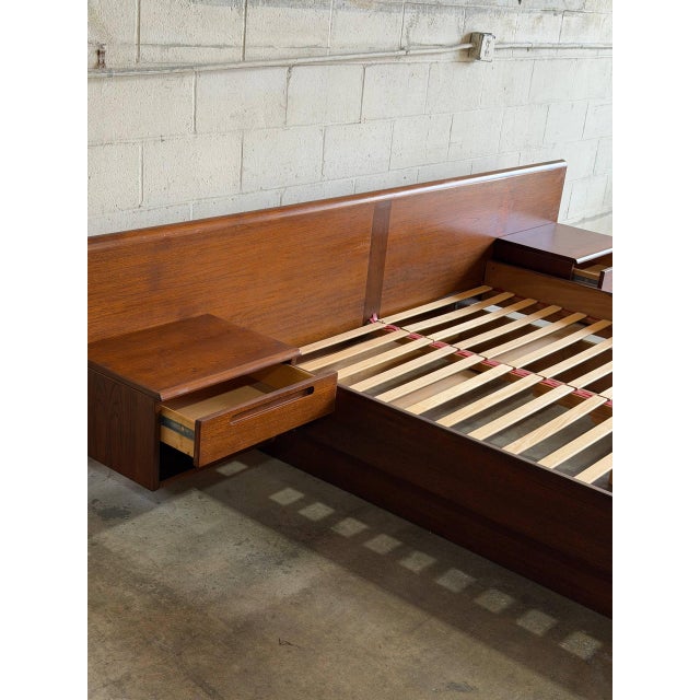 This striking queen-size platform bed features an expansive headboard seamlessly integrated with two floating nightstands....