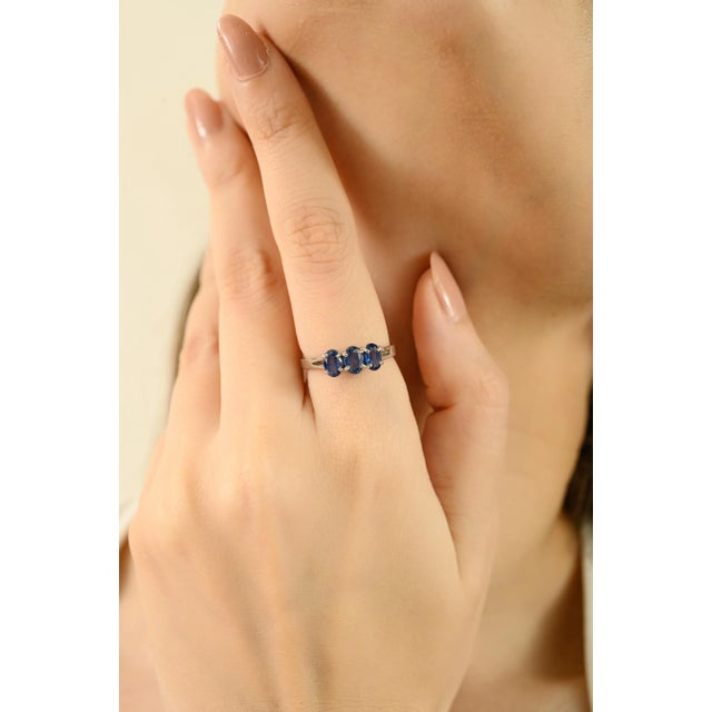 Exquisitely handcrafted in 925 sterling silver, this 1.65 ct blue sapphire three-stone unisex ring showcases the timeless...