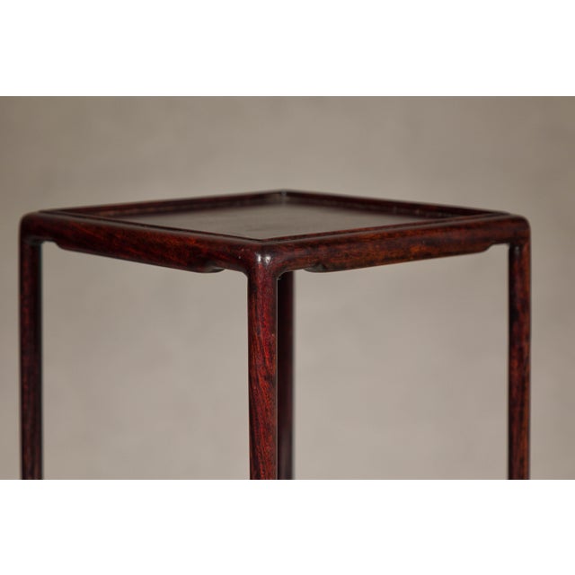 A set of five small size rosewood nesting tables with square inset tops, low humpback stretchers and reddish brown color....