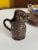 This is a rare, hand sculpted & slipped redware pitcher, depicting a full bodied lamb, made and signed by Ned Foltz. The...