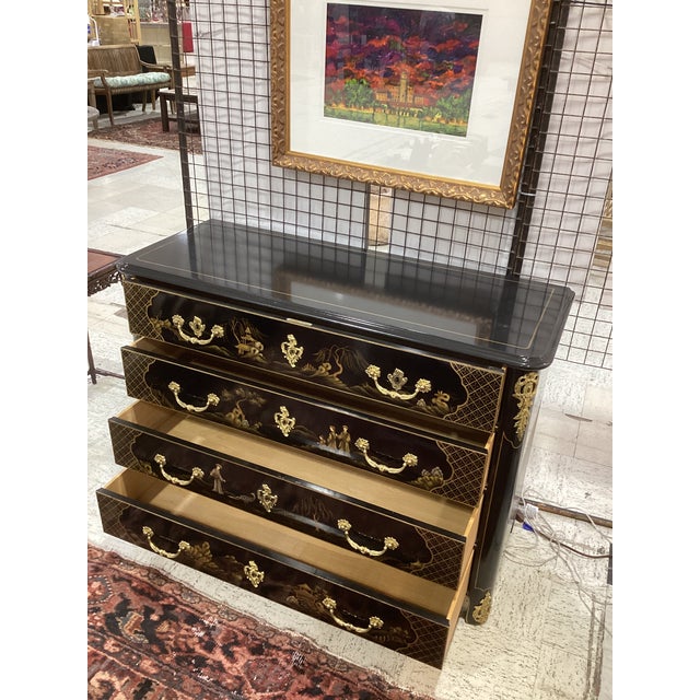 Elegant vintage four-drawer chinoiserie commode featuring a rich black lacquer finish with finely detailed gilt hand-...