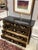 Elegant vintage four-drawer chinoiserie commode featuring a rich black lacquer finish with finely detailed gilt hand-...