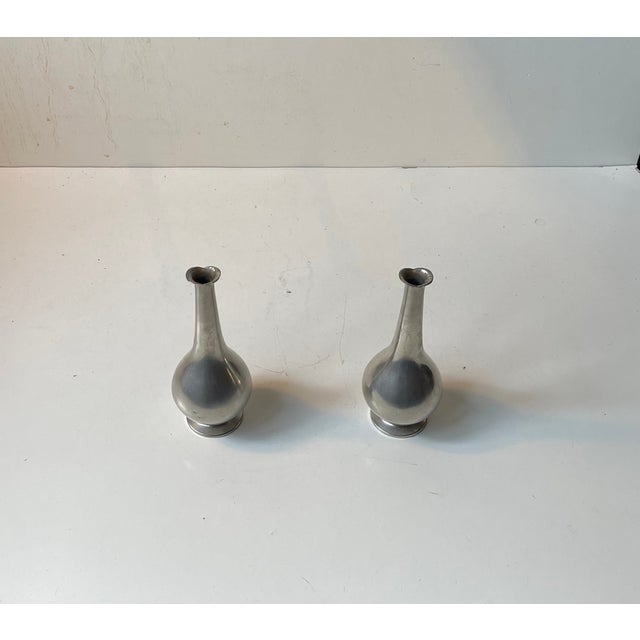 Small pewter vases with long neck and 'fish mouth'. Designed and manufactured by Just Andersen in Denmark during the...