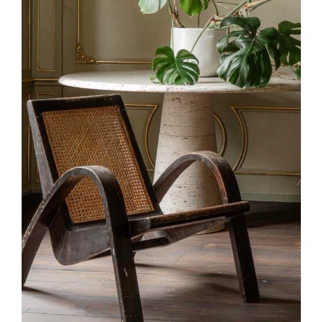 This pair of sculptural vintage lounge chair are characterized by its prominent, elegantly curved wooden arms and a hand-...
