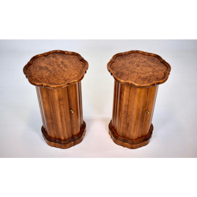A pair of scalloped walnut pedestal end /side table cabinets with single door and impressive book-matched burl wood grains...