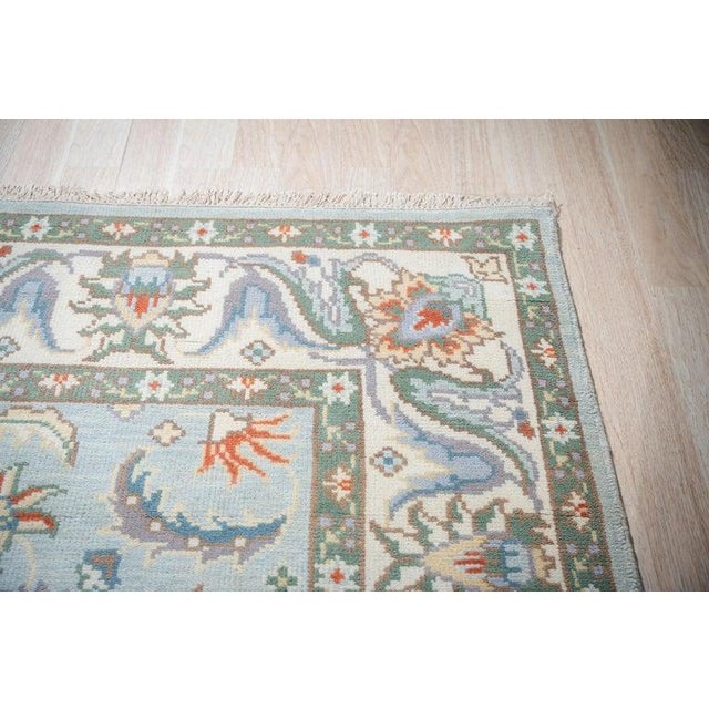 This blue wool rug features a hand knotted pile construction and adheres to the EORC Rugs style. The piece presents a...