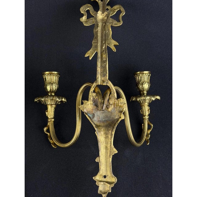 Elegant pair of French Louis XVI wall sconces dating from the late 19th to early 20th century. Beautifully cast in gilt...