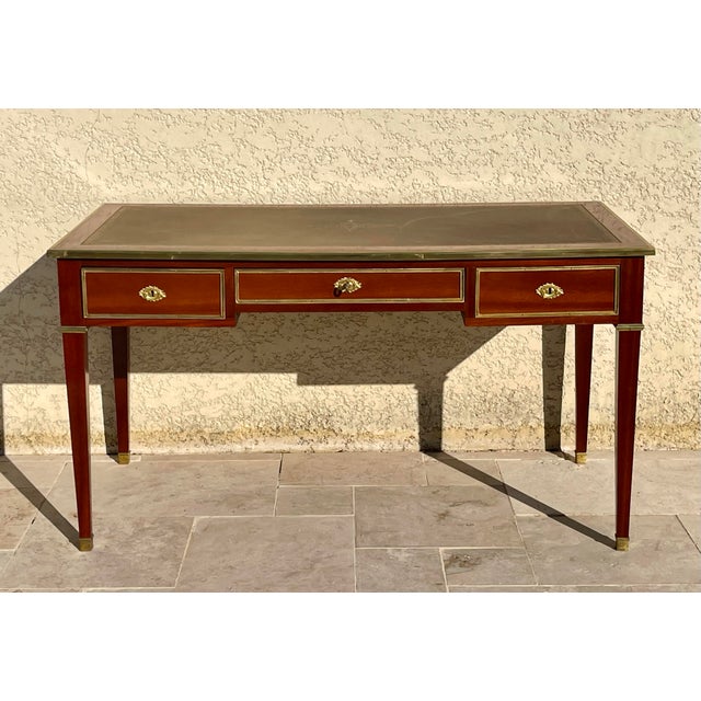 A louis xvi style mahogany and gilt bronze flat desk, composed of three drawers on one side and three false drawers on the...