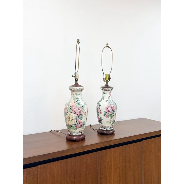 This lovely pair of vintage chinoiserie style table lamps with an off-white ground and delicate pink floral accents with...