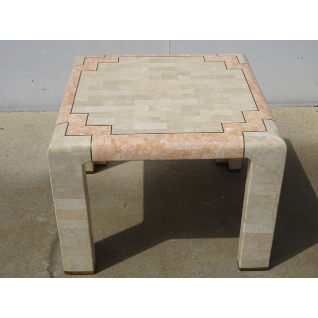 Square tabletop in two colors: ochre and pale pink. Inlaid with two distinct stones, with gilt brass inlays. Four angled...