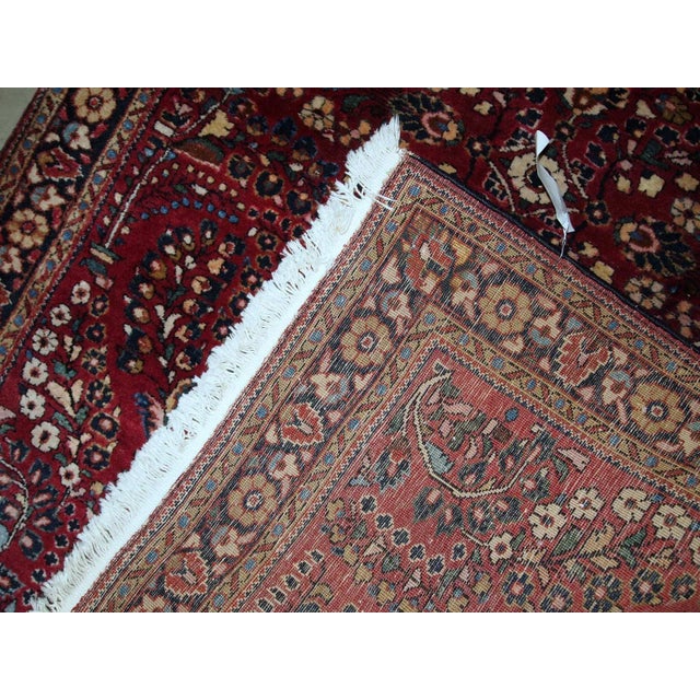 Handmade antique Sarouk rug in bright red colour. The rug is in original good condition from the beginning of 20th...
