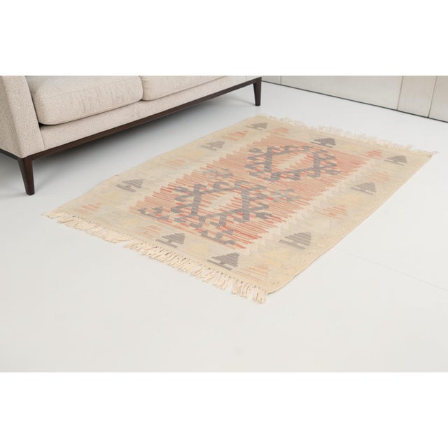 This is a vintage Turkish Oushak rug from the Mid 20th Century. The piece was hand-knotted.